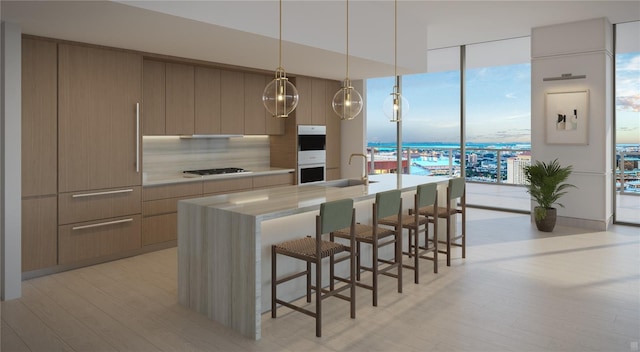 kitchen with light hardwood / wood-style flooring, a kitchen bar, white double oven, and sink