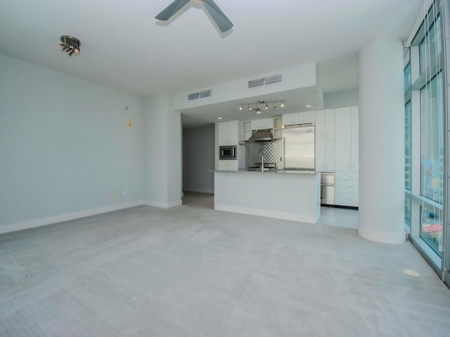 unfurnished living room with ceiling fan and light colored carpet