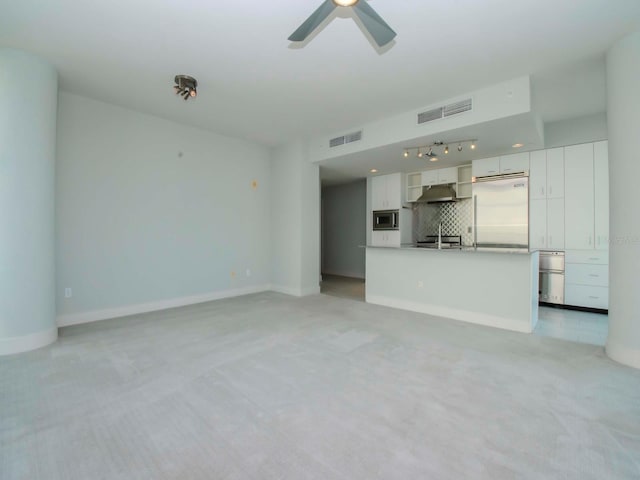 unfurnished living room featuring ceiling fan and light colored carpet