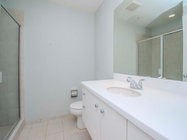 bathroom with vanity, toilet, a shower with door, and tile patterned floors