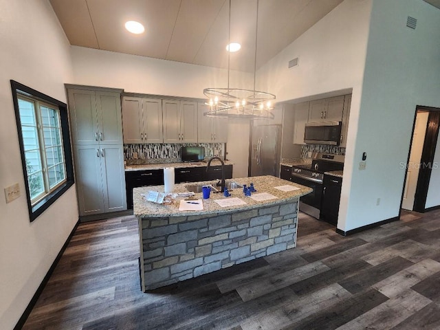 kitchen with appliances with stainless steel finishes, gray cabinetry, high vaulted ceiling, pendant lighting, and dark hardwood / wood-style floors