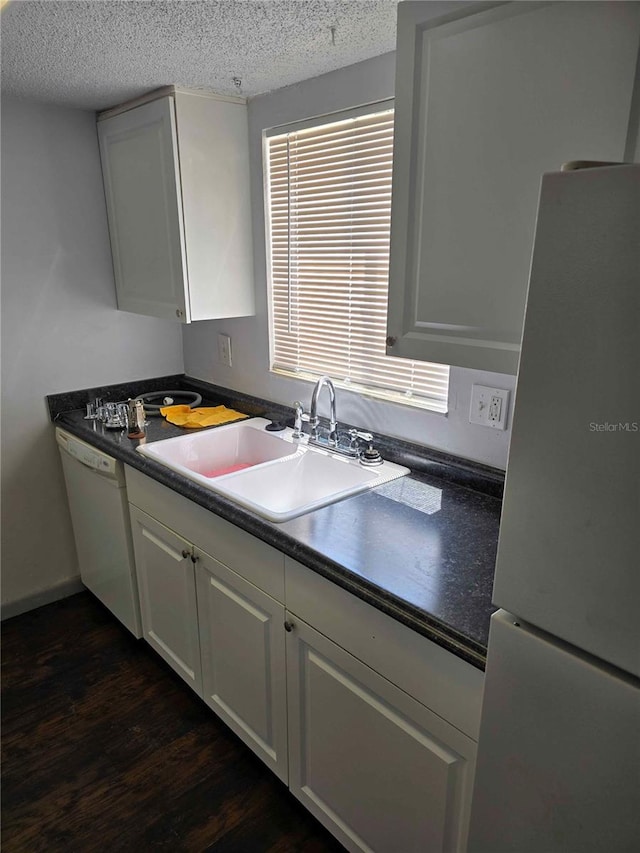 kitchen featuring dark hardwood / wood-style flooring, white appliances, a textured ceiling, sink, and white cabinetry