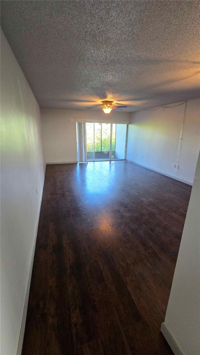 empty room featuring dark wood-type flooring and a textured ceiling