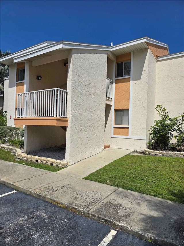 view of side of home featuring a balcony and stucco siding