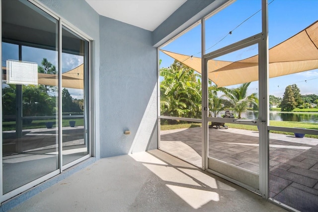 doorway to outside with a water view and concrete floors