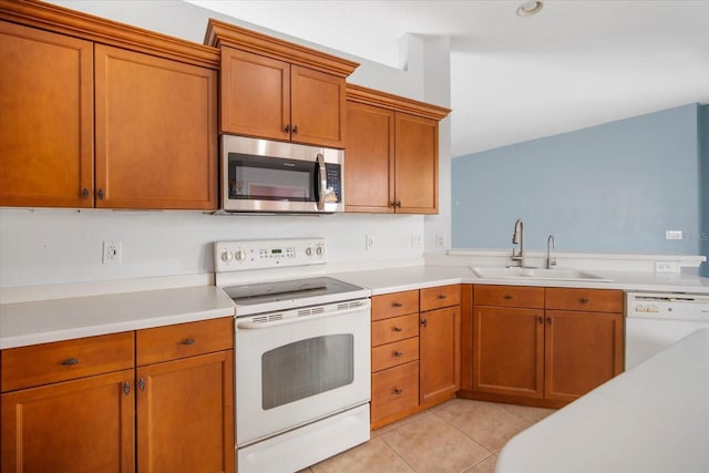 kitchen with light tile patterned floors, white appliances, and sink