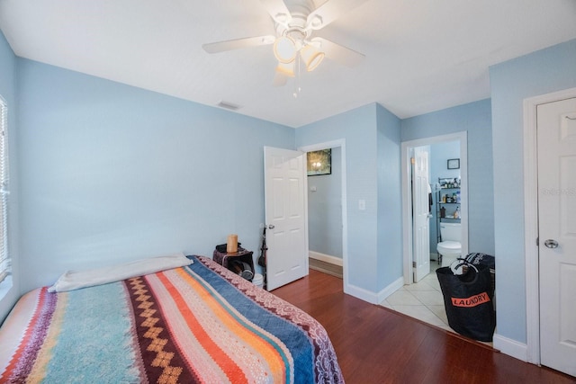 bedroom with ceiling fan, light hardwood / wood-style flooring, and connected bathroom