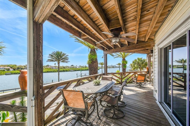 deck with ceiling fan and a water view