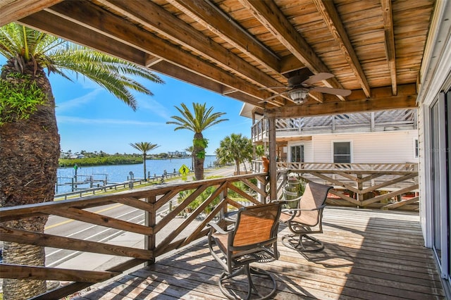 deck with ceiling fan and a water view