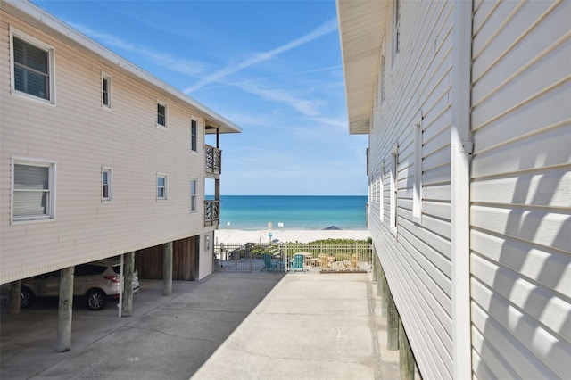 view of home's exterior featuring a water view and a beach view