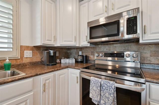 kitchen featuring white cabinets, appliances with stainless steel finishes, and tasteful backsplash