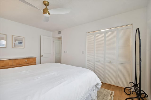 bedroom featuring ceiling fan, a closet, and light hardwood / wood-style flooring