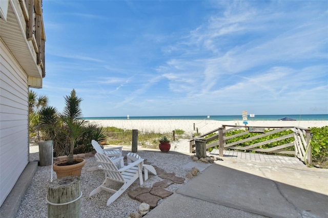 view of patio featuring a water view and a beach view