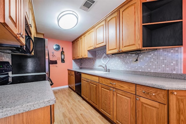 kitchen with light hardwood / wood-style flooring, black appliances, tasteful backsplash, and sink