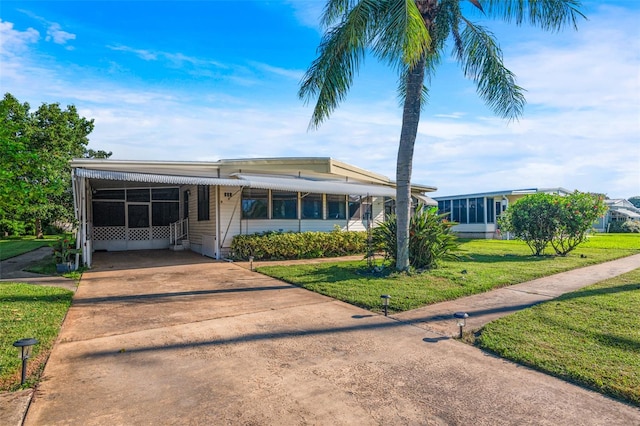 view of front of house featuring a front lawn and a carport