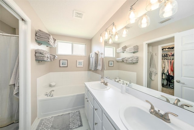 bathroom featuring a bath, tile patterned flooring, and vanity