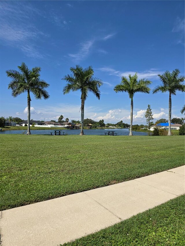 view of home's community featuring a water view and a yard