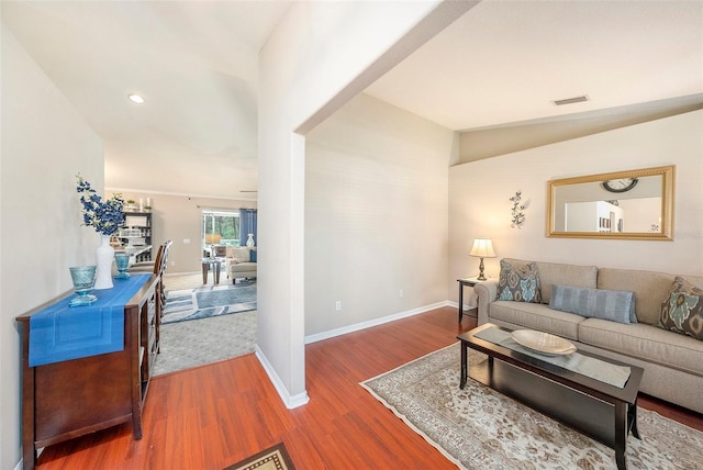 living room with wood-type flooring and vaulted ceiling