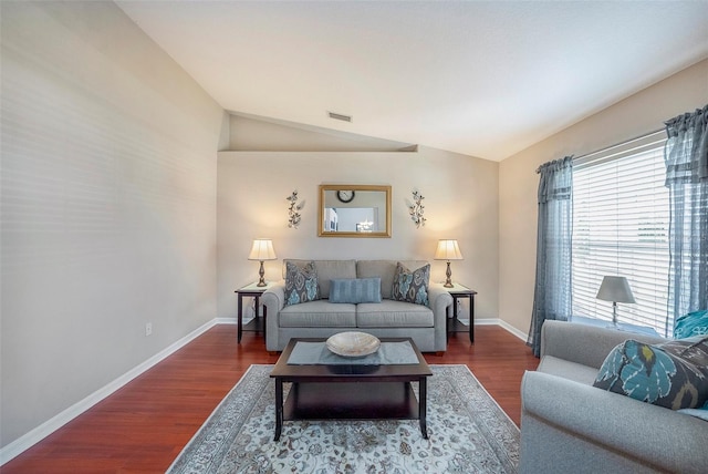 living room featuring dark wood-type flooring and vaulted ceiling