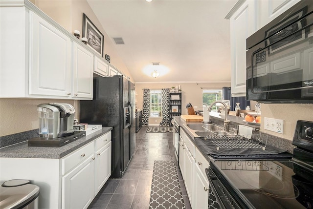 kitchen with lofted ceiling, white cabinets, and black appliances