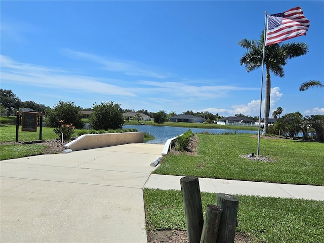 view of community featuring a lawn and a water view