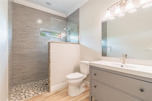 bathroom featuring vanity, crown molding, hardwood / wood-style floors, and tiled shower