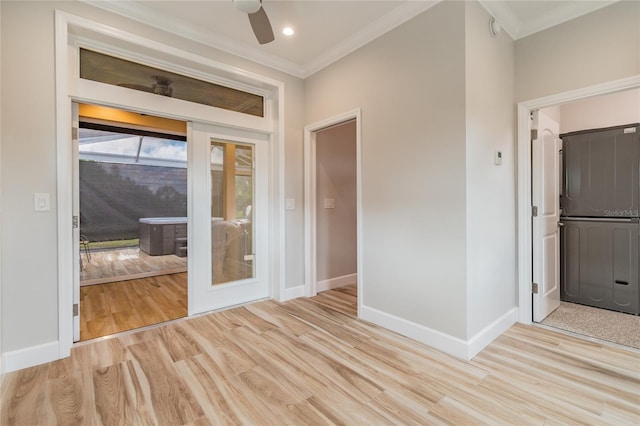 empty room featuring ceiling fan, light wood-type flooring, and ornamental molding