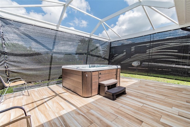 wooden terrace with glass enclosure and a hot tub