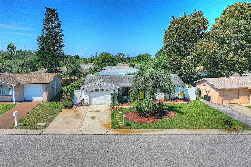 view of front of home featuring a garage, fence, concrete driveway, a gate, and a front lawn