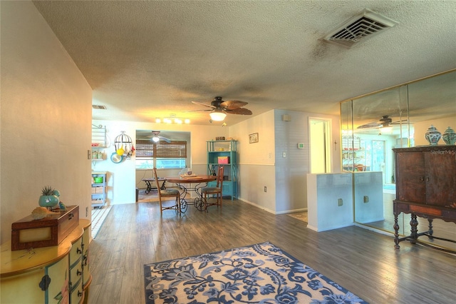 dining area featuring visible vents, a textured ceiling, and wood finished floors