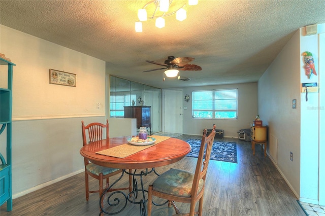 dining area featuring a textured ceiling, wood finished floors, and ceiling fan with notable chandelier