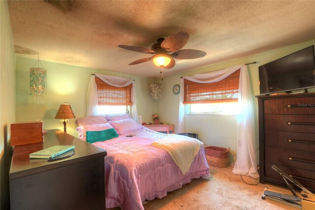 bedroom with carpet floors, ceiling fan, and a textured ceiling