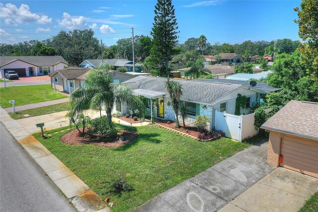 ranch-style house with a residential view, a gate, driveway, and a front yard