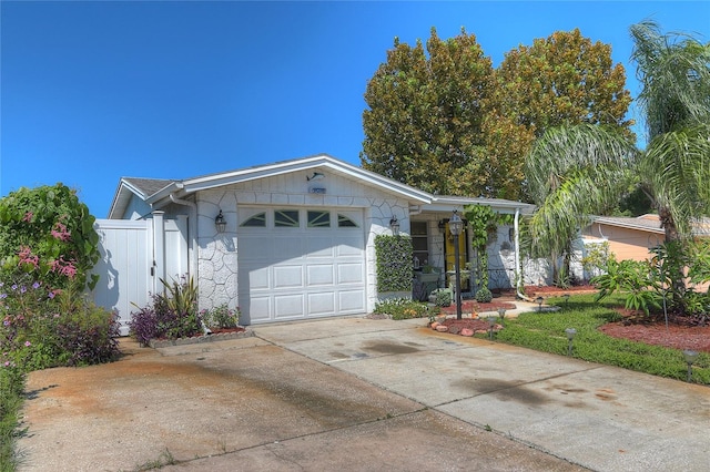 ranch-style home with a garage, driveway, and fence