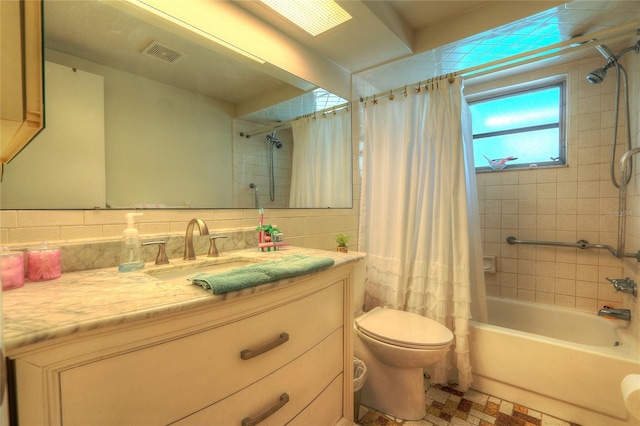 bathroom with vanity, visible vents, tile walls, shower / tub combo with curtain, and tasteful backsplash