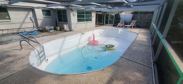 view of pool with a lanai, fence, and a patio