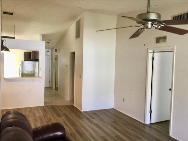 unfurnished living room with ceiling fan, dark wood-type flooring, and lofted ceiling