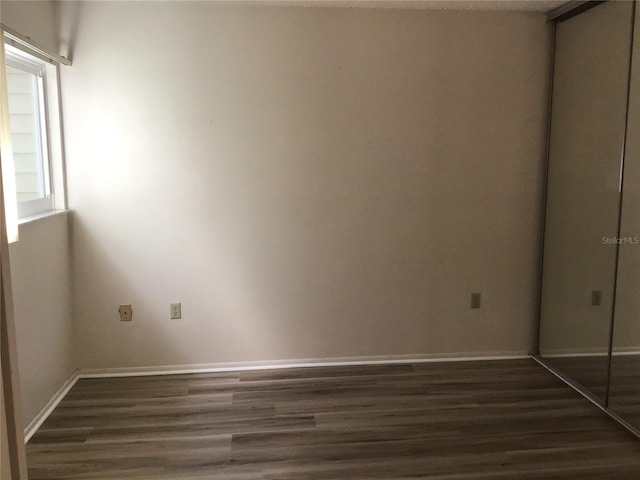 spare room with dark wood-type flooring