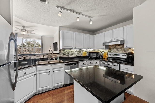 kitchen with decorative backsplash, white cabinets, stainless steel appliances, ceiling fan, and sink