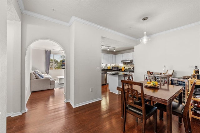 dining space with track lighting, ornamental molding, a textured ceiling, and dark hardwood / wood-style flooring