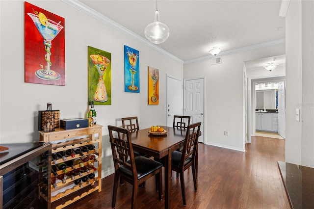 dining room with wine cooler, crown molding, dark hardwood / wood-style flooring, and a textured ceiling