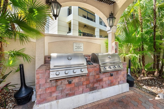 view of patio with a balcony, exterior kitchen, and area for grilling