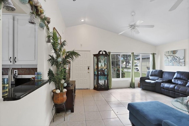 tiled living room featuring ceiling fan and high vaulted ceiling