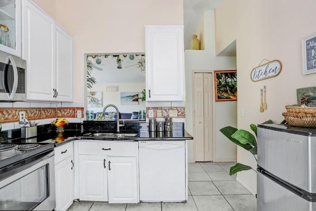 kitchen featuring stainless steel appliances, light tile patterned flooring, white cabinets, and sink