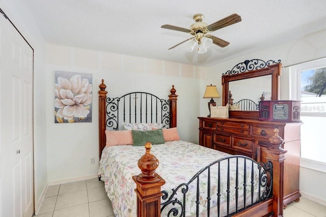 bedroom with light tile patterned flooring, ceiling fan, and a closet