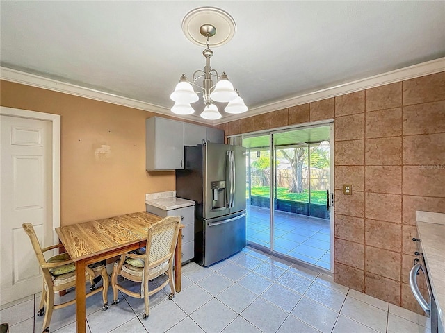 unfurnished dining area featuring light tile patterned floors, a notable chandelier, and ornamental molding