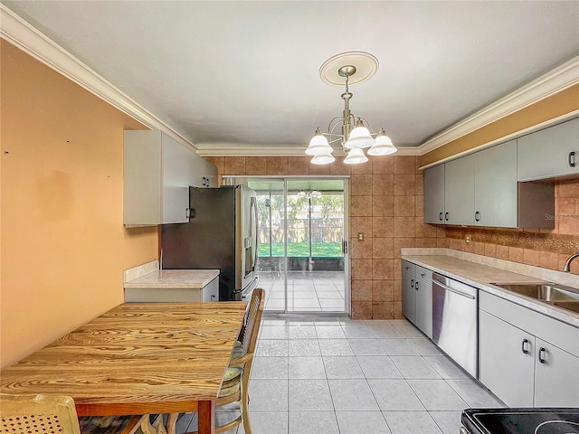 kitchen with pendant lighting, tile walls, a chandelier, sink, and appliances with stainless steel finishes