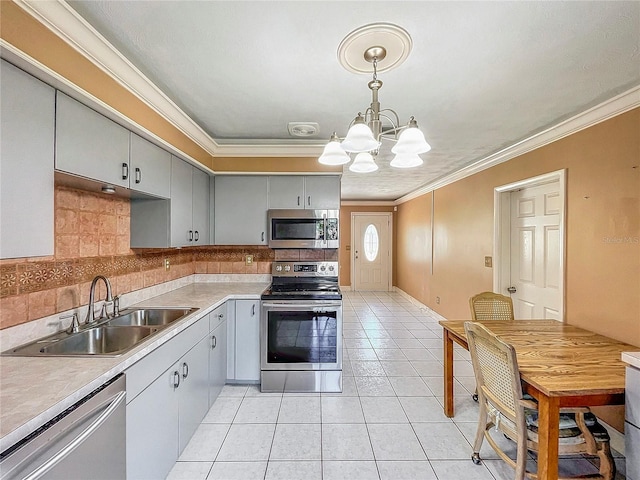 kitchen with appliances with stainless steel finishes, an inviting chandelier, decorative light fixtures, ornamental molding, and sink