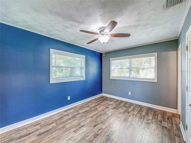 empty room with a textured ceiling, ceiling fan, hardwood / wood-style floors, and crown molding