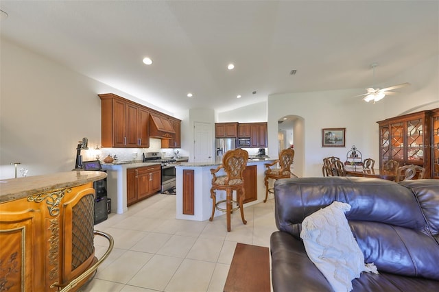 kitchen featuring custom exhaust hood, appliances with stainless steel finishes, ceiling fan, decorative backsplash, and lofted ceiling